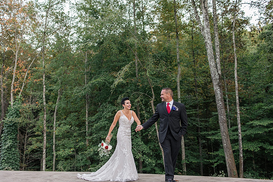groom leading bride in woods