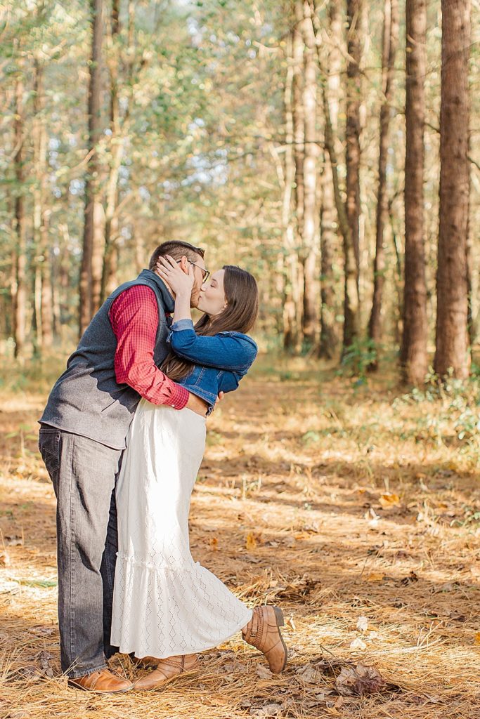 couple sharing a dip kiss in woods