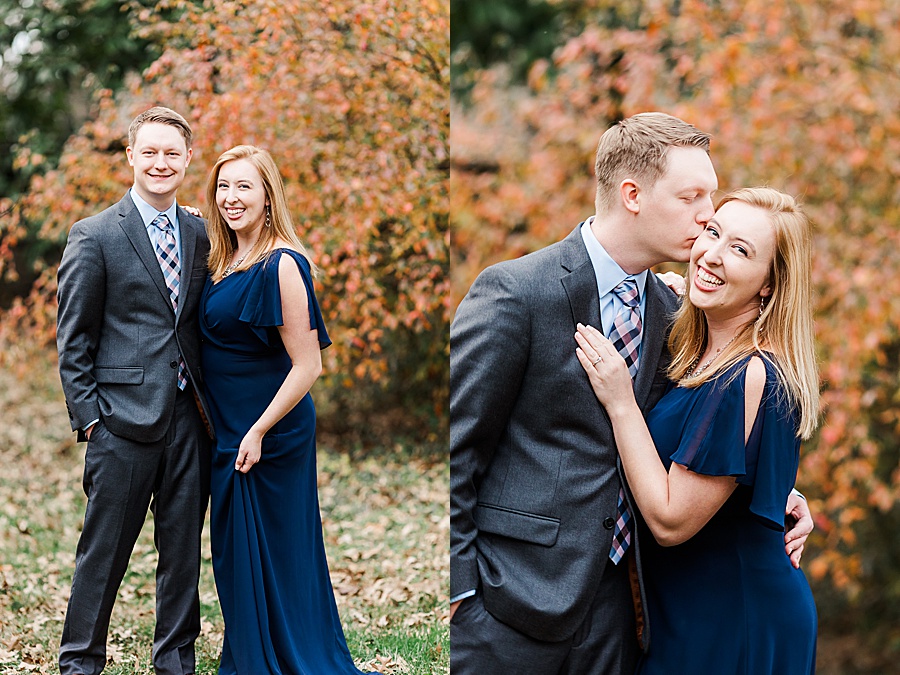 couple embracing in fall color leaves and navy dress
