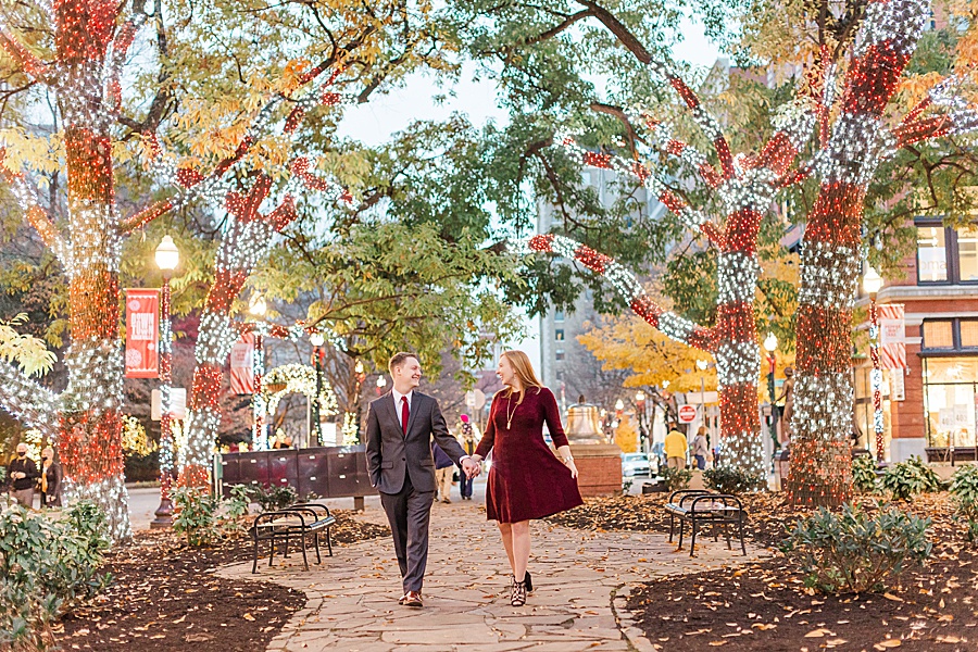 couple walking in downtown with christmas lights