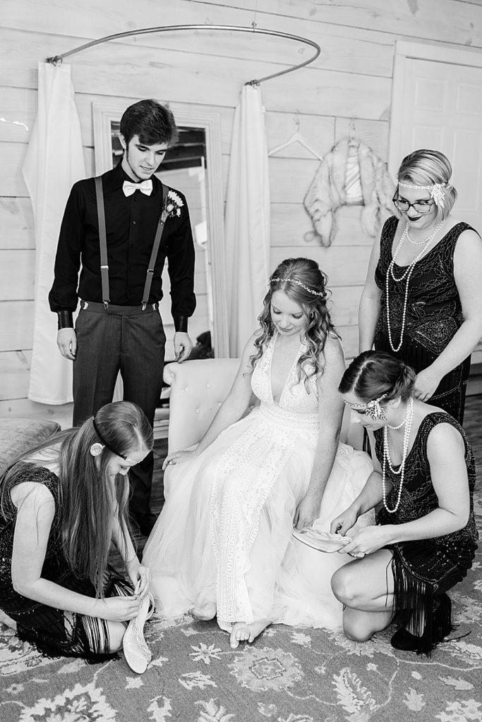 bridesmaids assisting bride getting ready in black and white
