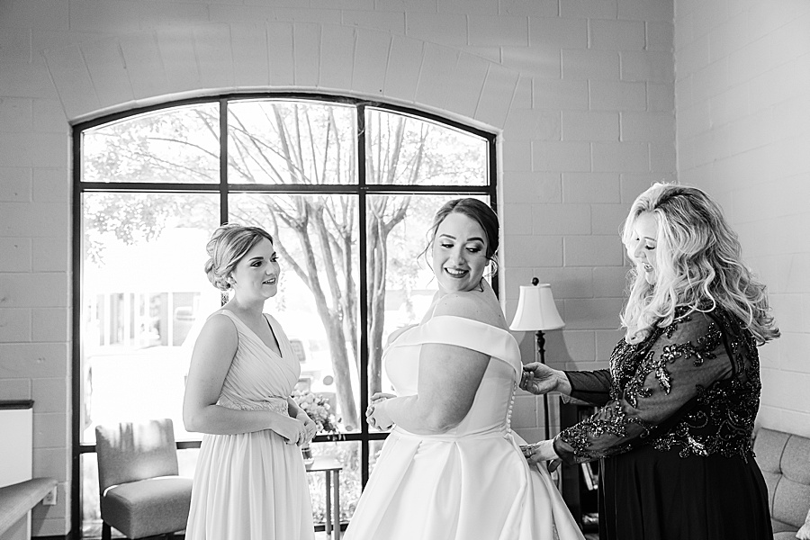 black and white of mom and sister helping bride get ready