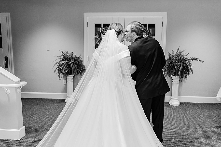 father kissing daughter before walking her down the aisle