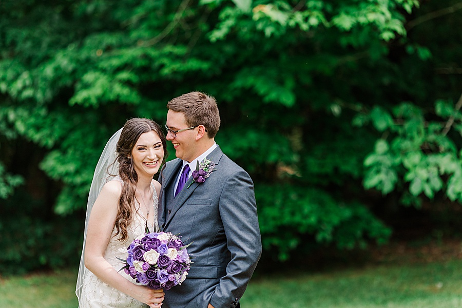bride and groom cuddling in grey and lavender