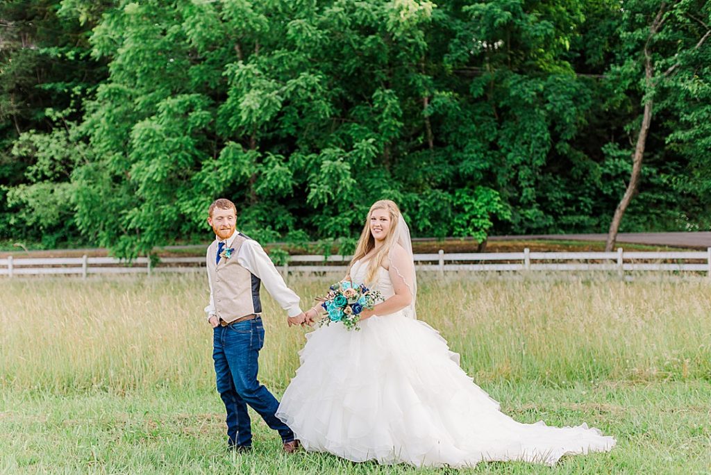 bride and groom walking in field of tall grass