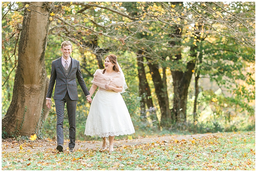 vintage-wedding-forest-blush-fur-couple-walking-holding-hands