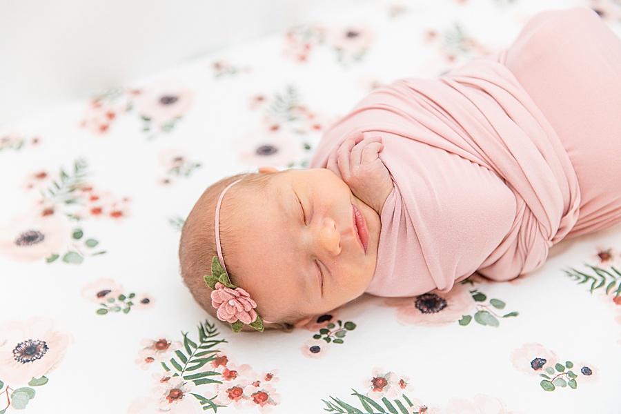 newborn in pink on flower blanket
