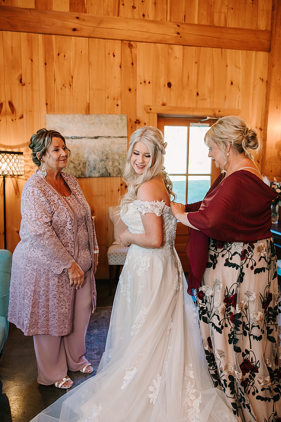 mom and grandma helping bride get dressed