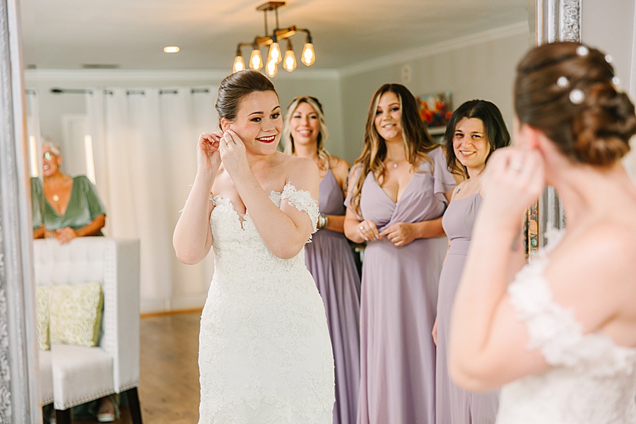 Bride putting in earrings on wedding day