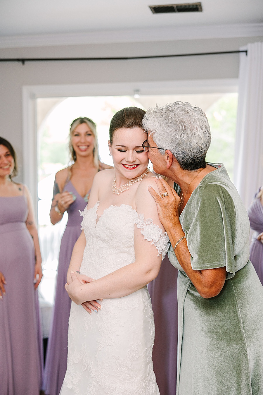 Mother kissing bride on wedding day