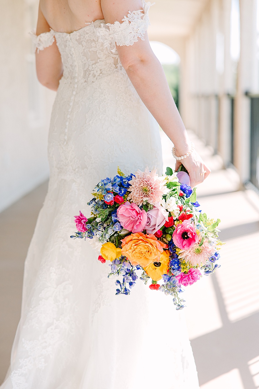 bride holding vibrant floral wedding bouquet on wedding day
