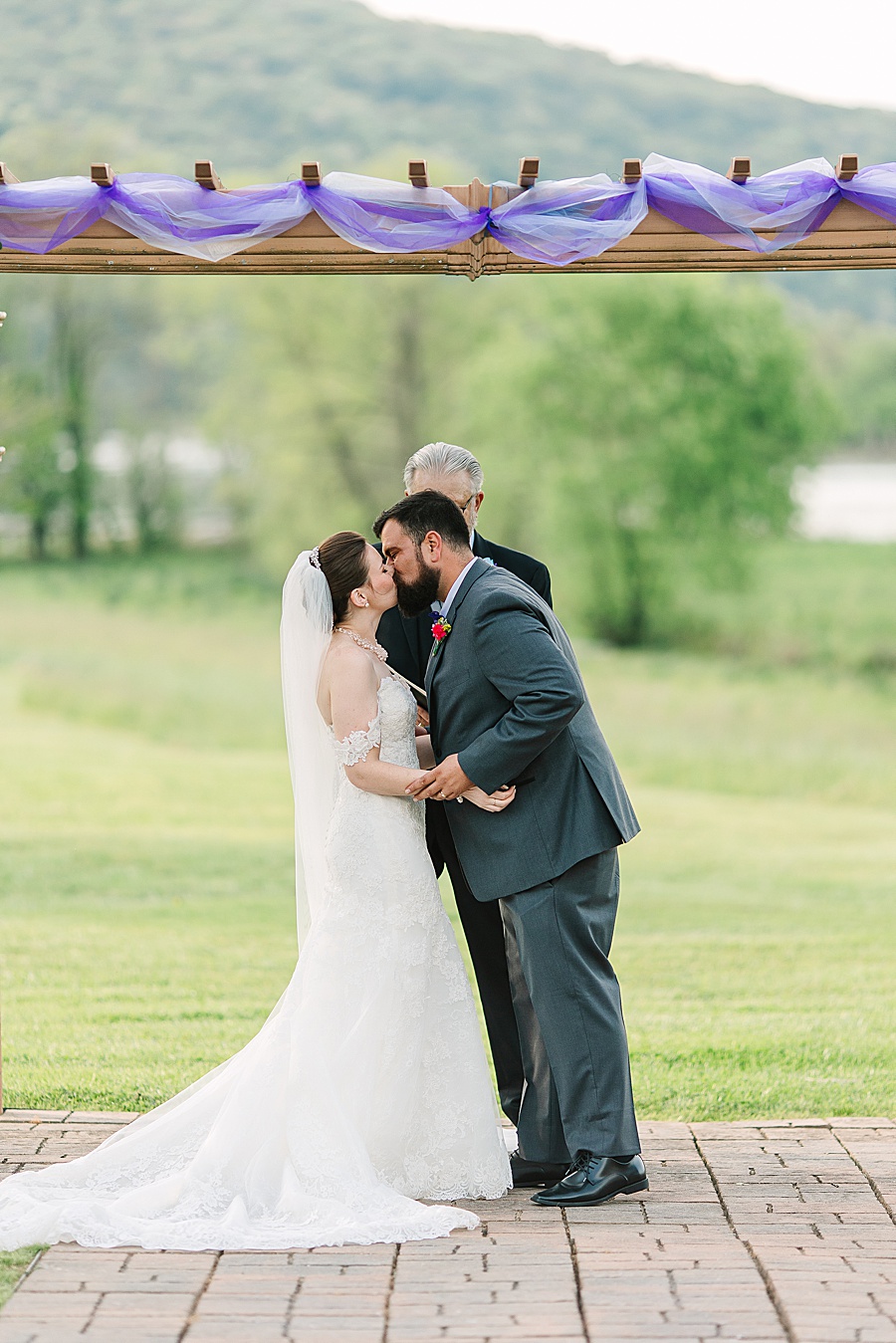 bride and groom kissing as husband and wife during wedding ceremony