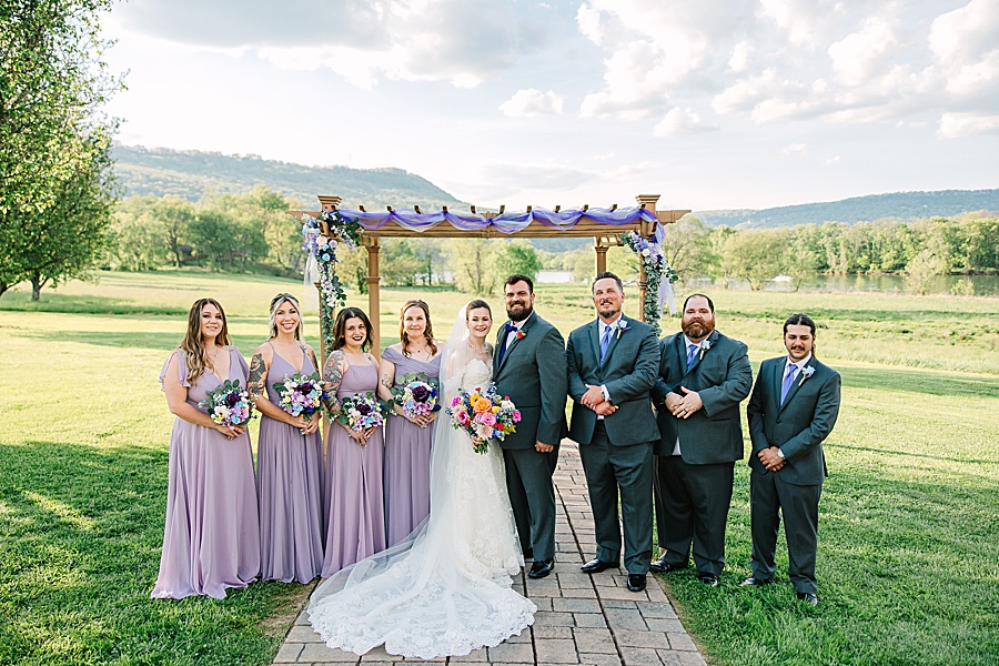 bridal party in front of arbor at river front wedding at Tennessee Riverplace in Chattanooga