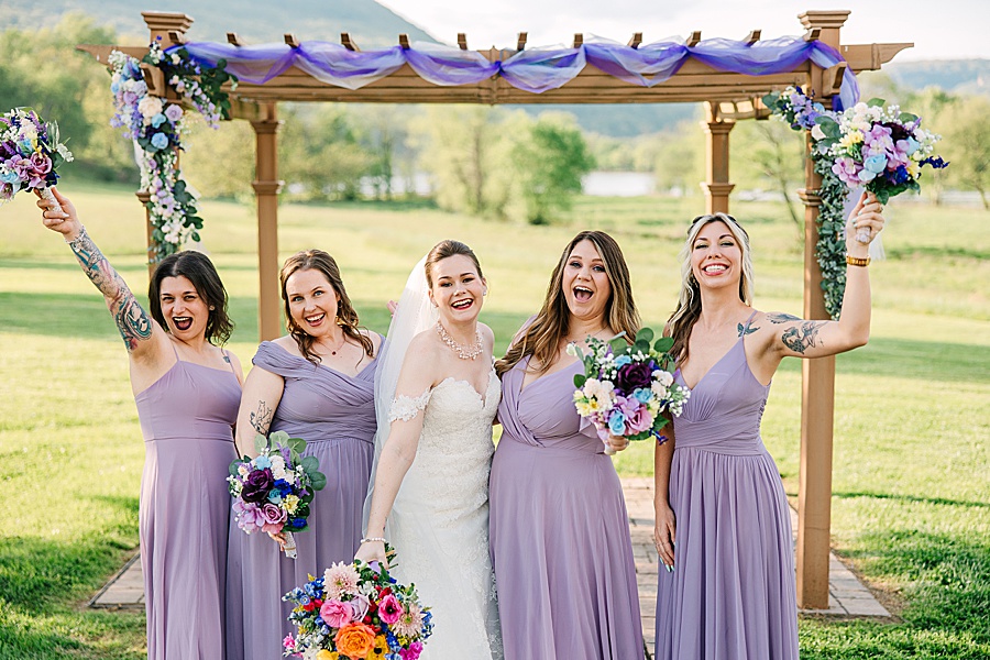 bride and bridesmaids cheering at wedding arbor
