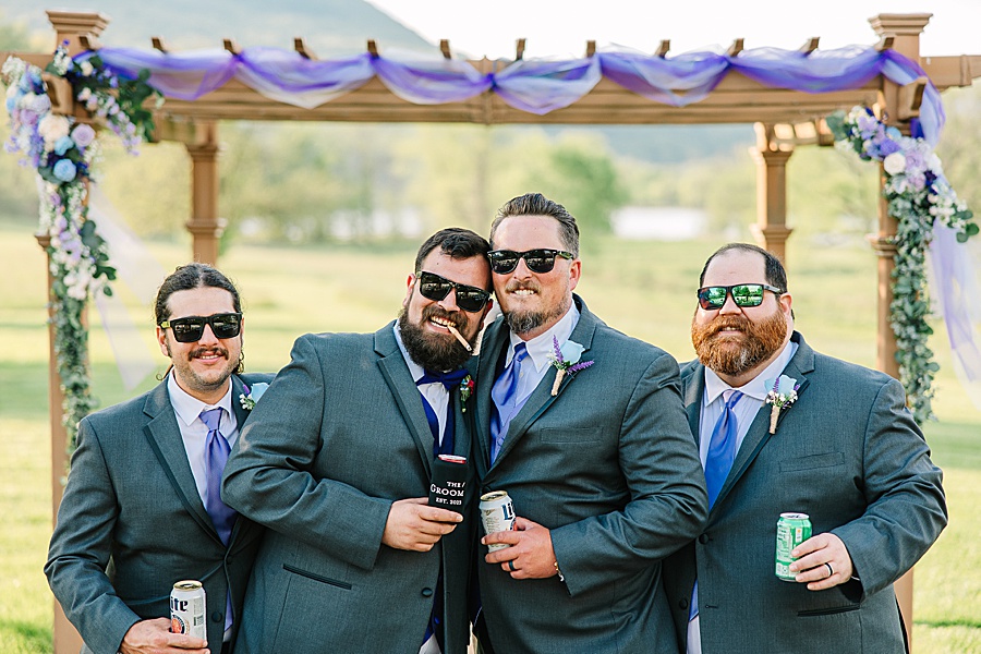 groom and groomsmen with cigars and beverages