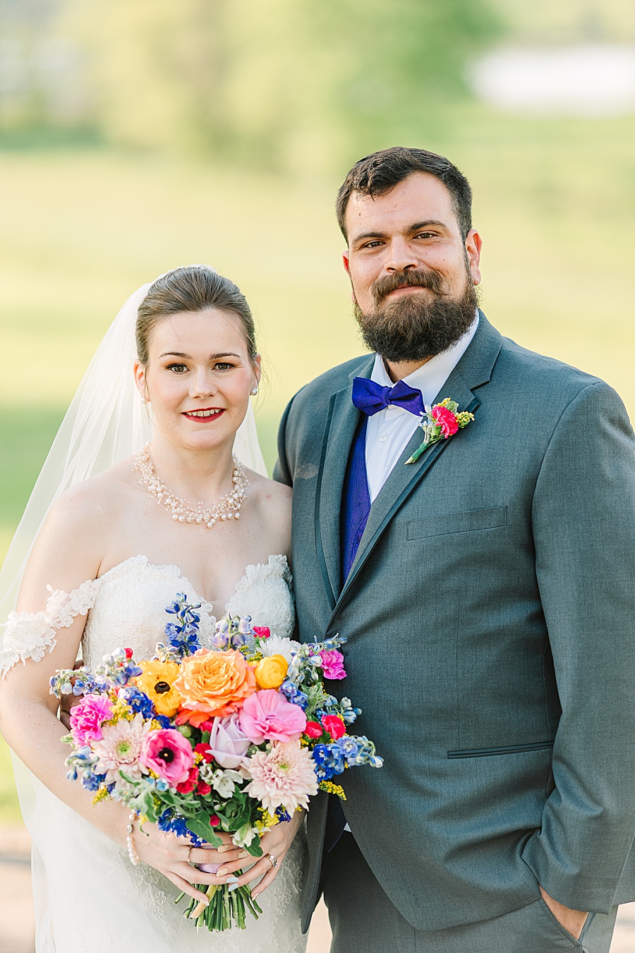bride and groom portrait with vibrant floral bouquet