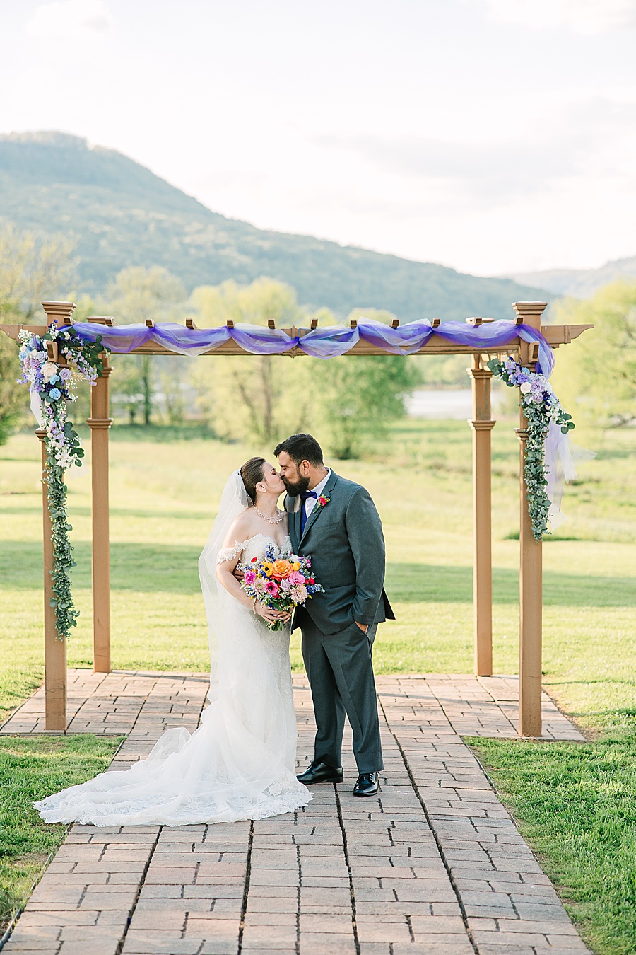 Bride and groom kissing at arbor at Tennessee Riverplace in Chattanooga