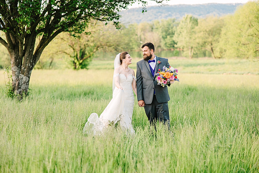 Bride and groom walking in field of tall grass at Tennessee Riverplace in Chattanooga