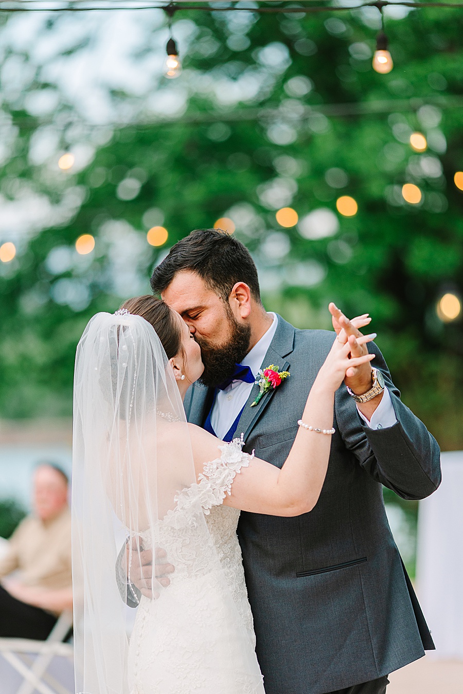 bride and groom kissing while dancing at reception