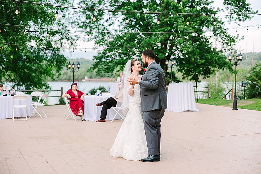 Bride and groom dancing at river front wedding reception