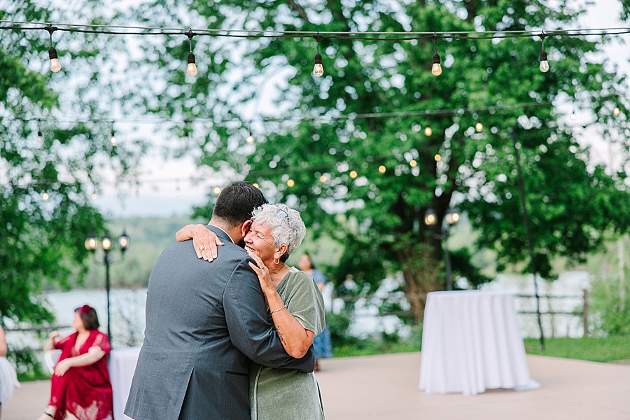 mother and son dancing at river front wedding reception