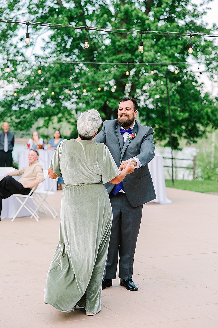 mother and groom dancing at river front wedding reception