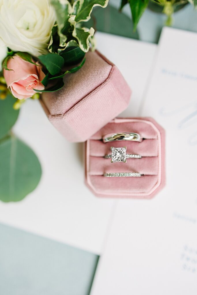 White gold wedding rings with princess cut stone in pink velvet ring box