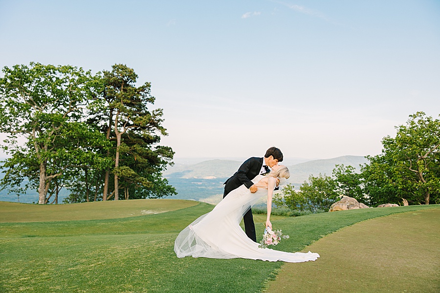 bride and groom dip kissing atop lookout mountain at the McLemore club golf course