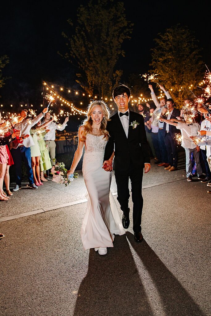 bride and groom exiting wedding via a sparkler tunnel