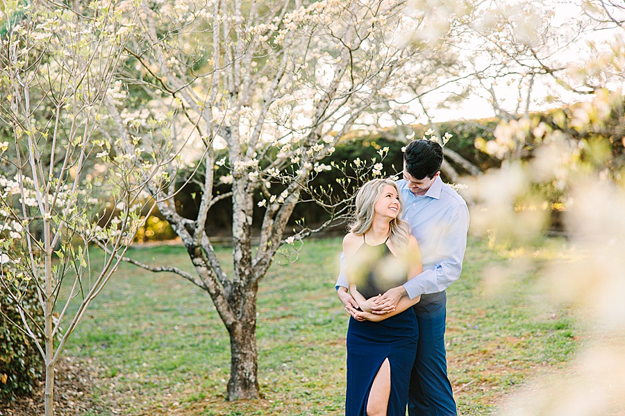 couple embracing in a dogwood meadow