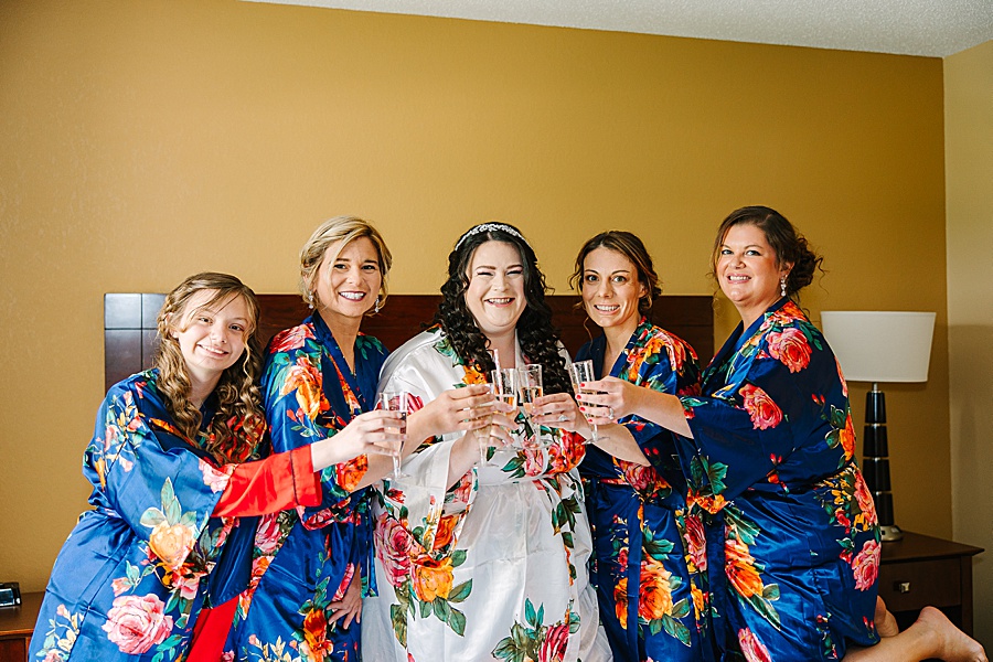 bride and bridesmaids toasting in robes before wedding
