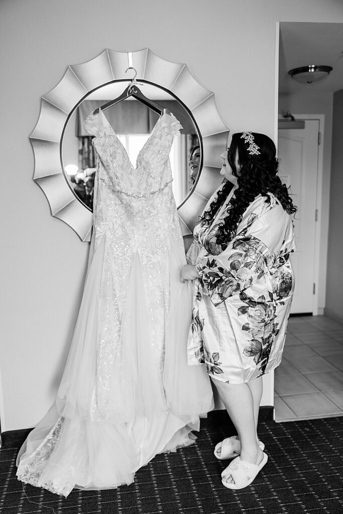 bride looking at her wedding dress before putting it on