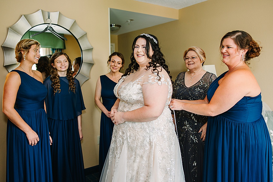 bride getting ready with her bridesmaids and mom
