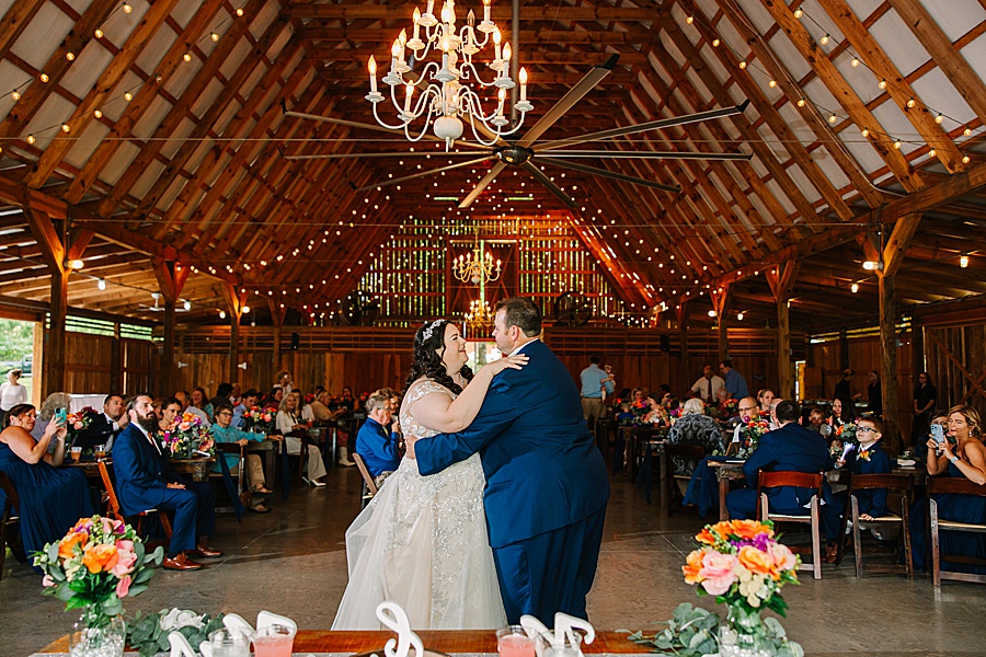 bride and groom dancing under lights and chandeliers at riverview farms wedding