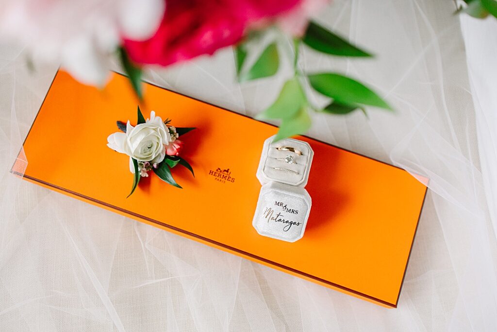 wedding rings and boutonniere on Hermes tie box