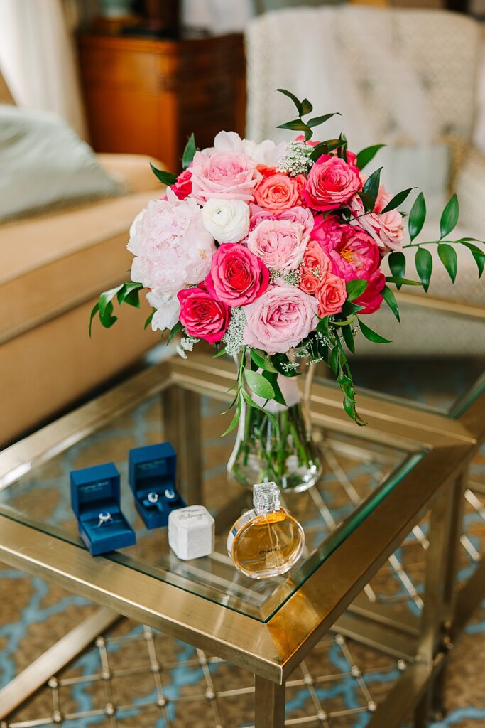 Bridal bouquet and rings and perfume on table