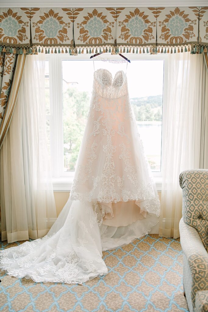 lace wedding dress hanging in window of Broadmoor resort