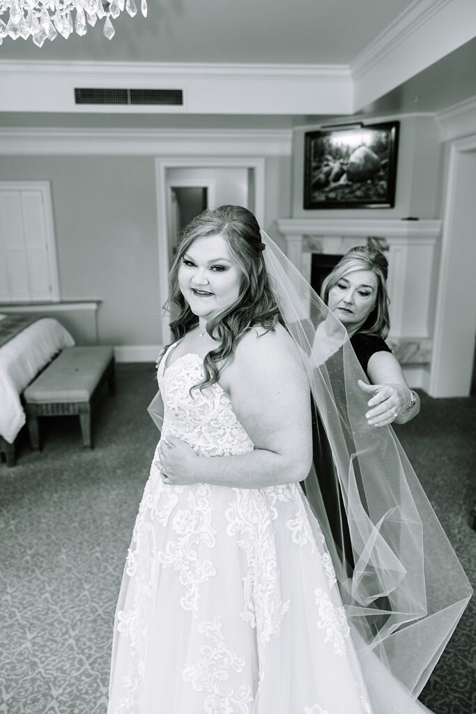 black and white image of mom putting veil on daughter on wedding day