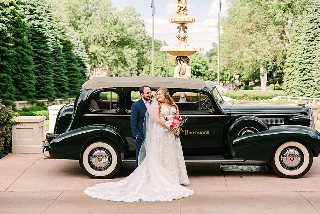 bride and groom with the broadmoor car on their wedding day