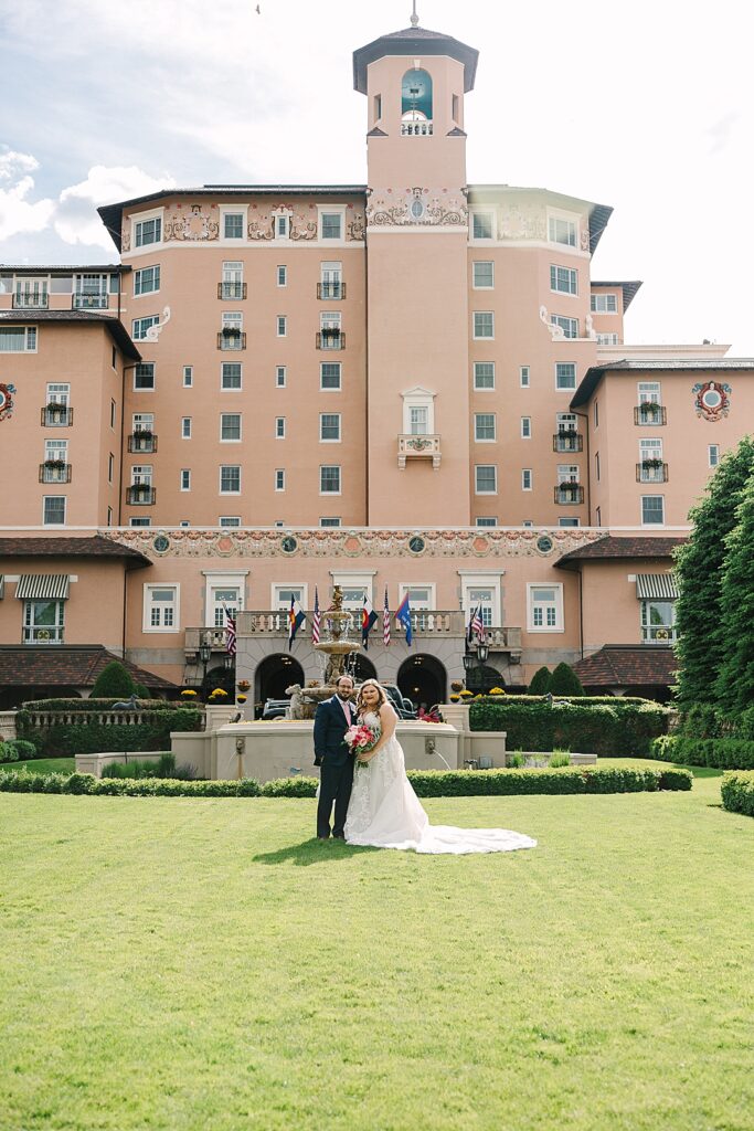 bride and groom on the front lawn of the Broadmoor resort in Colorado Springs Co.