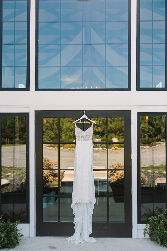 wedding dress hanging on the doors of candies creek farm wedding venue