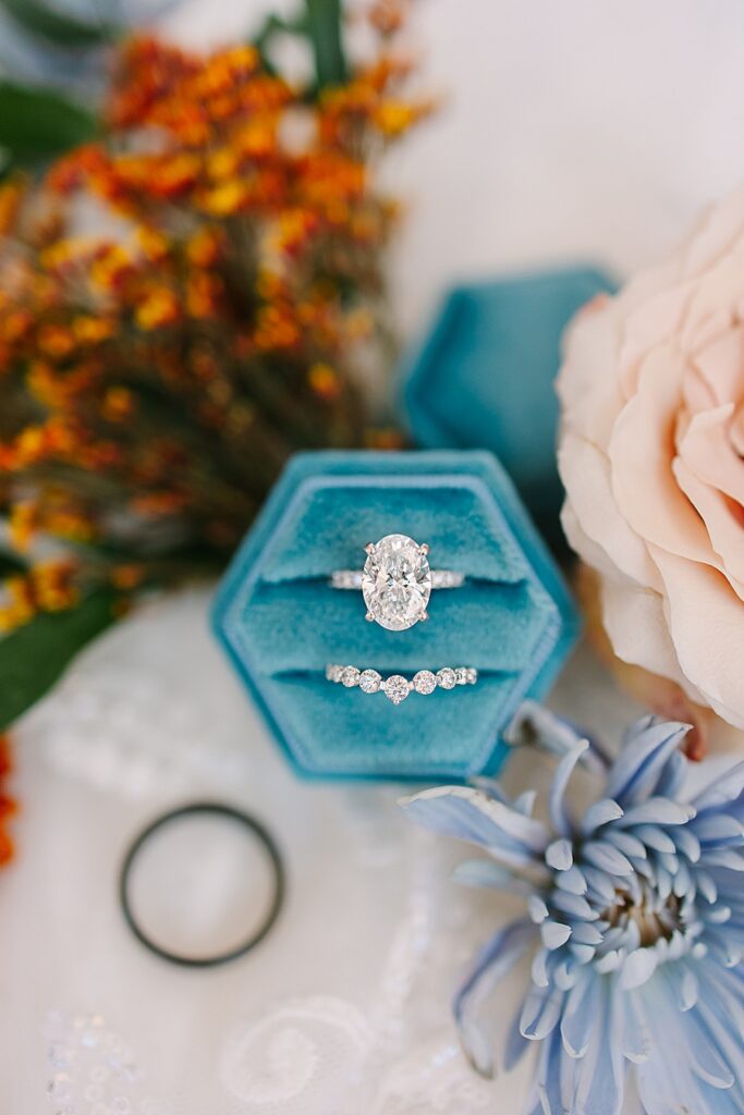 oval engagement ring in blue velvet box with fall florals