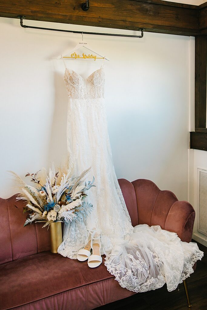 wedding dress hanging in candies creek farm bridal suite with florals and shoes