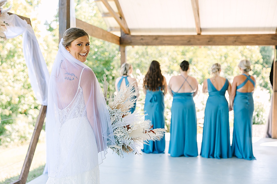 first look with bridesmaids and bride at fall wedding at candies creek farm