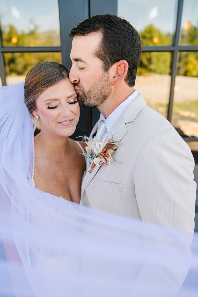 bride and groom in intimate embrace with flying veil at candies creek farm fall wedding