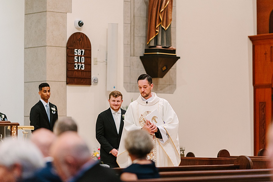 priest entering the chapel before catholic wedding ceremony