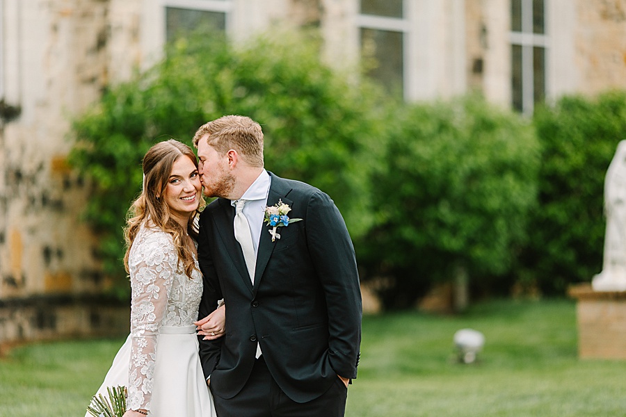 bride and groom kissing outside of church