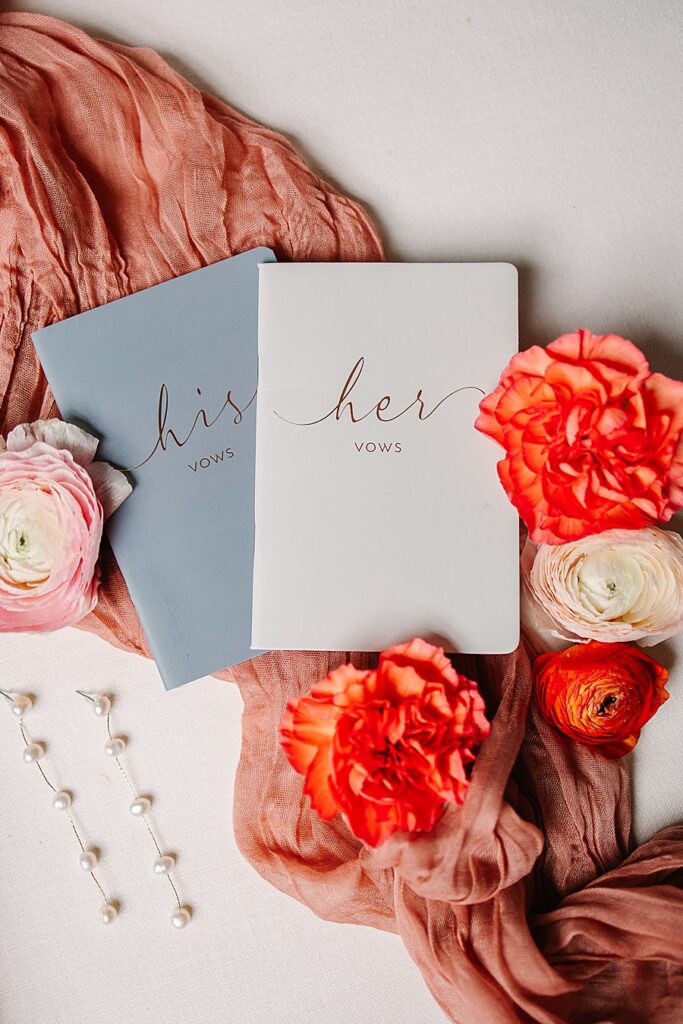 vow books with florals and pearl earrings