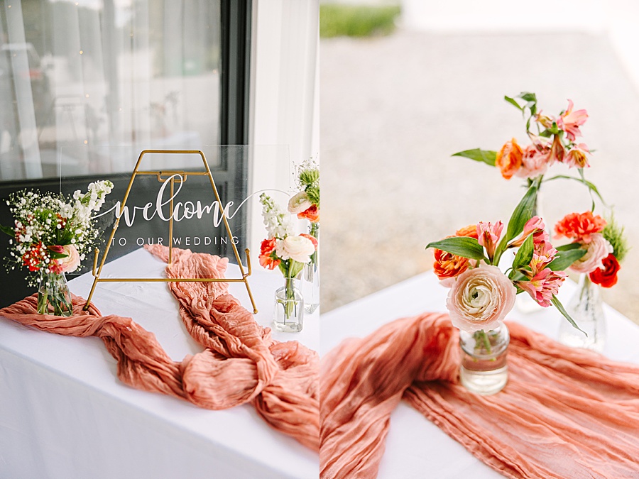 wedding welcome sign with soft florals of ranunculus and garden roses at the venue at the bluffs wedding