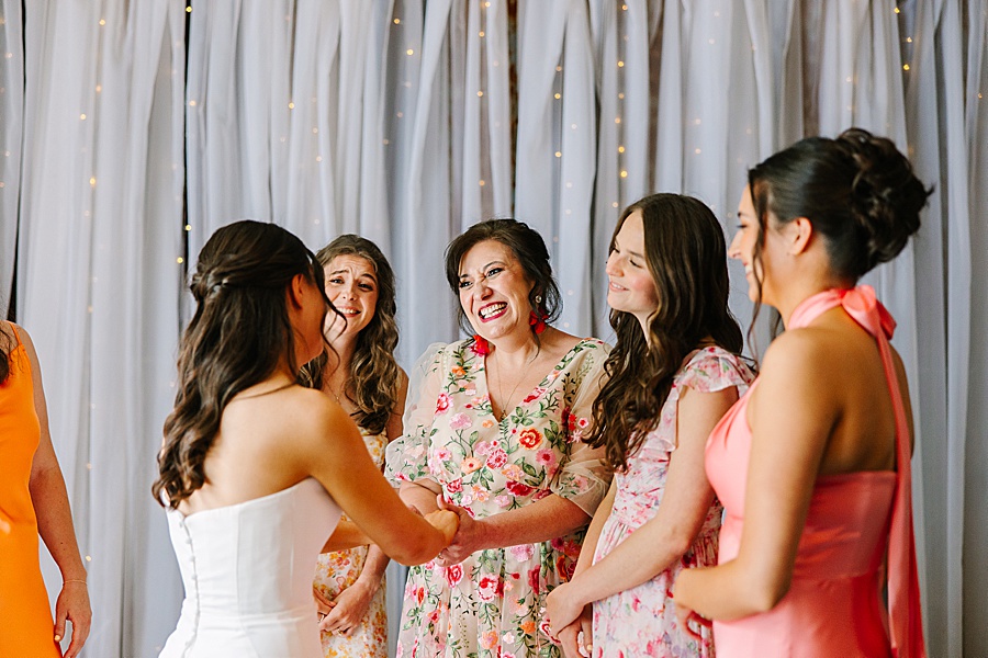 mom smiling at daughter on her wedding day while getting ready for wedding at venue at the bluffs